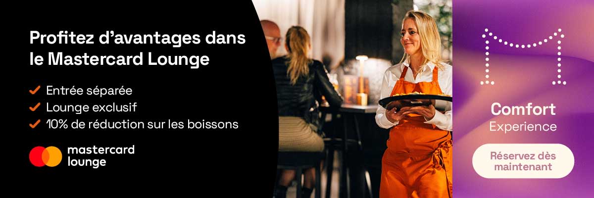 Intérieur du Mastercard Lounge avec un membre du personnel servant des boissons à des visiteurs dans un espace lounge.