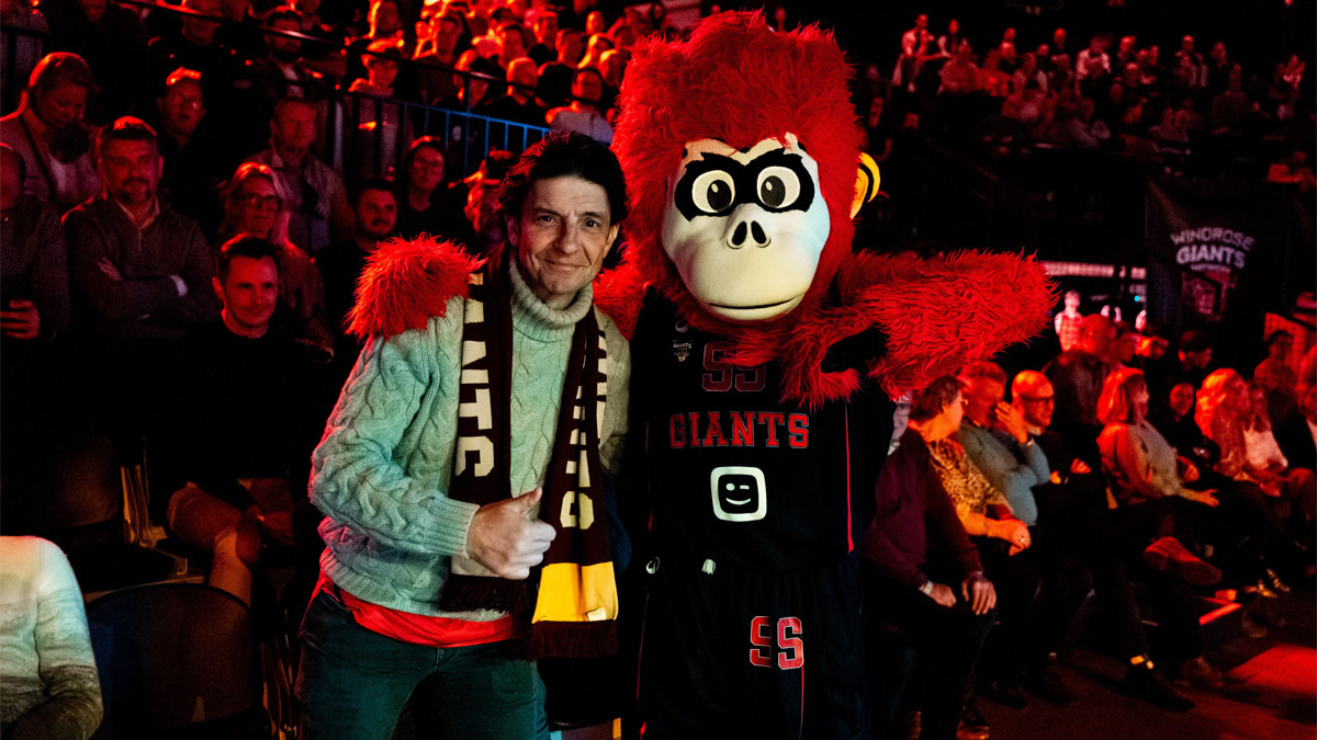 Koen Wauters van Clouseau staat naast de mascotte van Windrose Giants Antwerp.