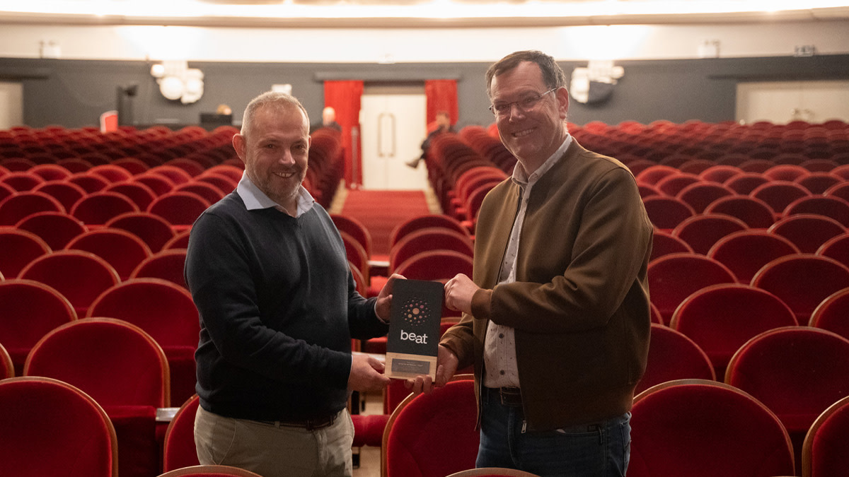 Theaterdirecteur Ralf Geheniau overhandigd de welverdiende be•at Award aan comedian Arnout Van den Bossche.