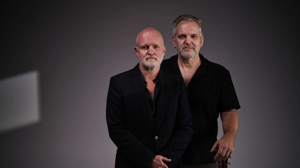 De broers Walschaert in zwarte outfit tegen een grijze achtergrond.