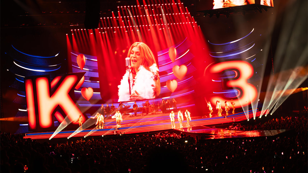 K3 treedt op voor een uitverkochte zaal in de AFAS Dome, met een groots podium vol rode lichteffecten, hartjes en gigantische verlichte letters tijdens K3 Originals.
