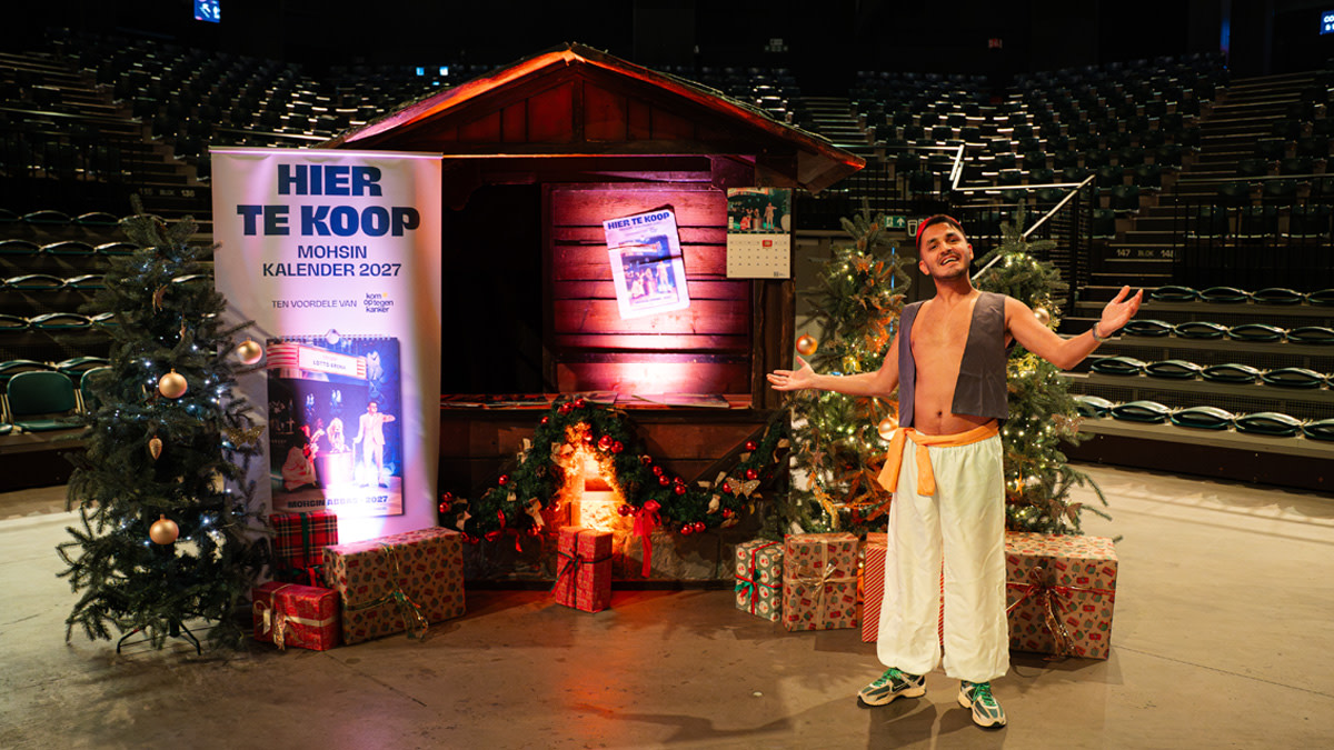 Mohsin Abbas poseert in de Lotto Arena voor een kerststalletje waarin hij zijn kalenders promoot en verkoopt.