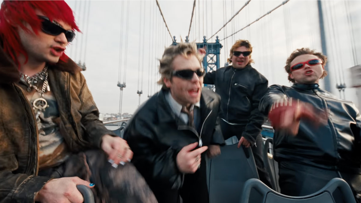 De vier bandleden van 5SOS op een toeristenbus in de video bij 'Everyone's a Star'.