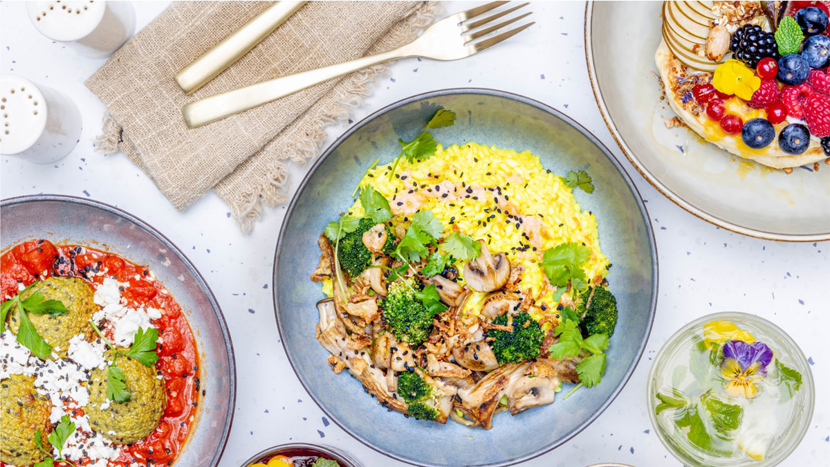 Colourful dishes on a set table at the Ghent restaurant Modest, served in a bright and atmospheric setting.