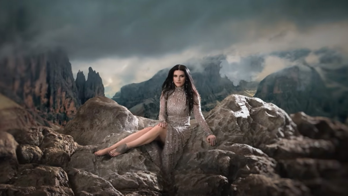 Laura Pausini zittend op een grote rots naar aanleiding van haar nieuwe single 'La Mia Storia Tra Le Dito'.