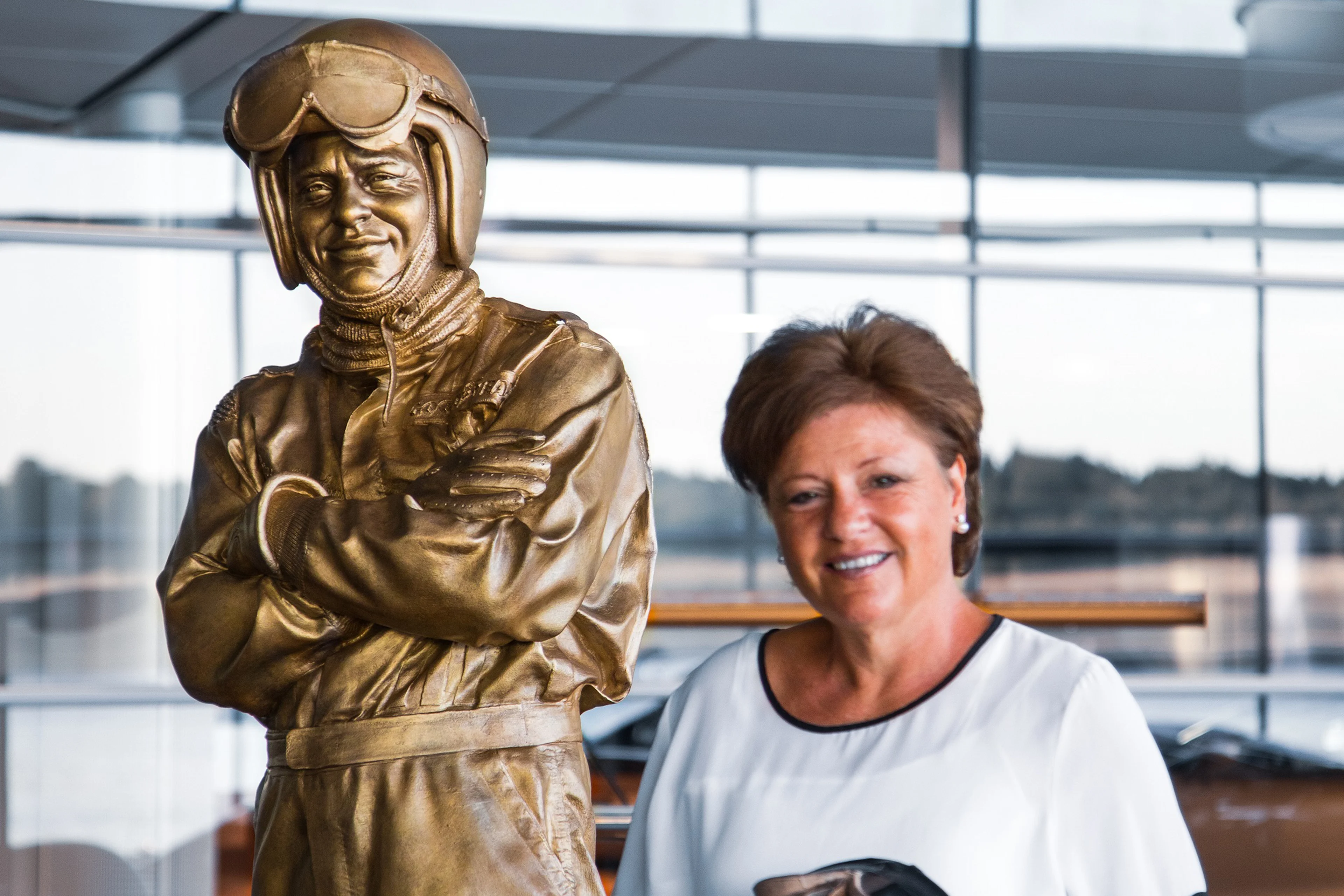 Amanda McLaren alongside the statue of her father, Bruce, at the McLaren Technology Centre