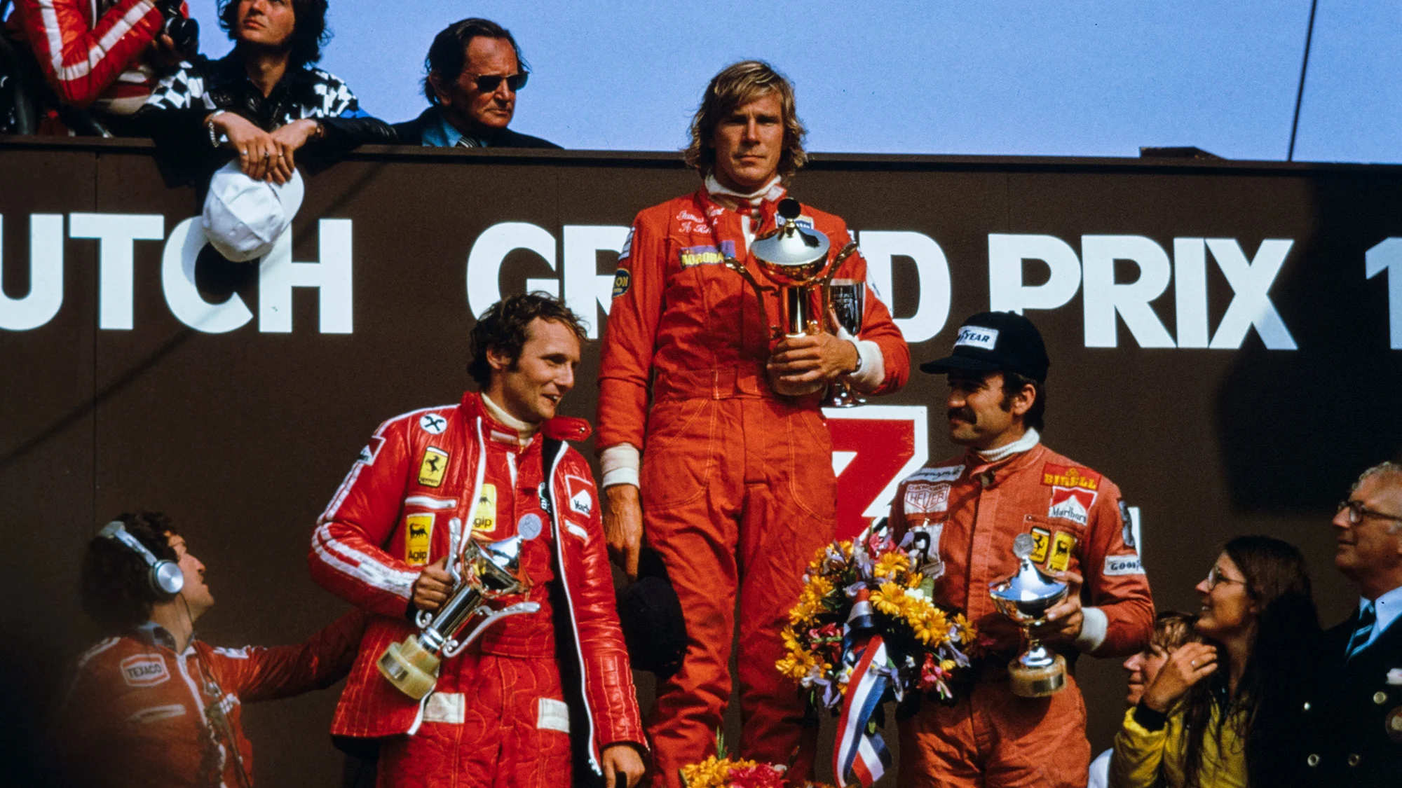 James Hunt celebrates victory on the podium with Niki Lauda, and Clay Regazzoni during the Dutch GP at Zandvoort on June 22, 1975