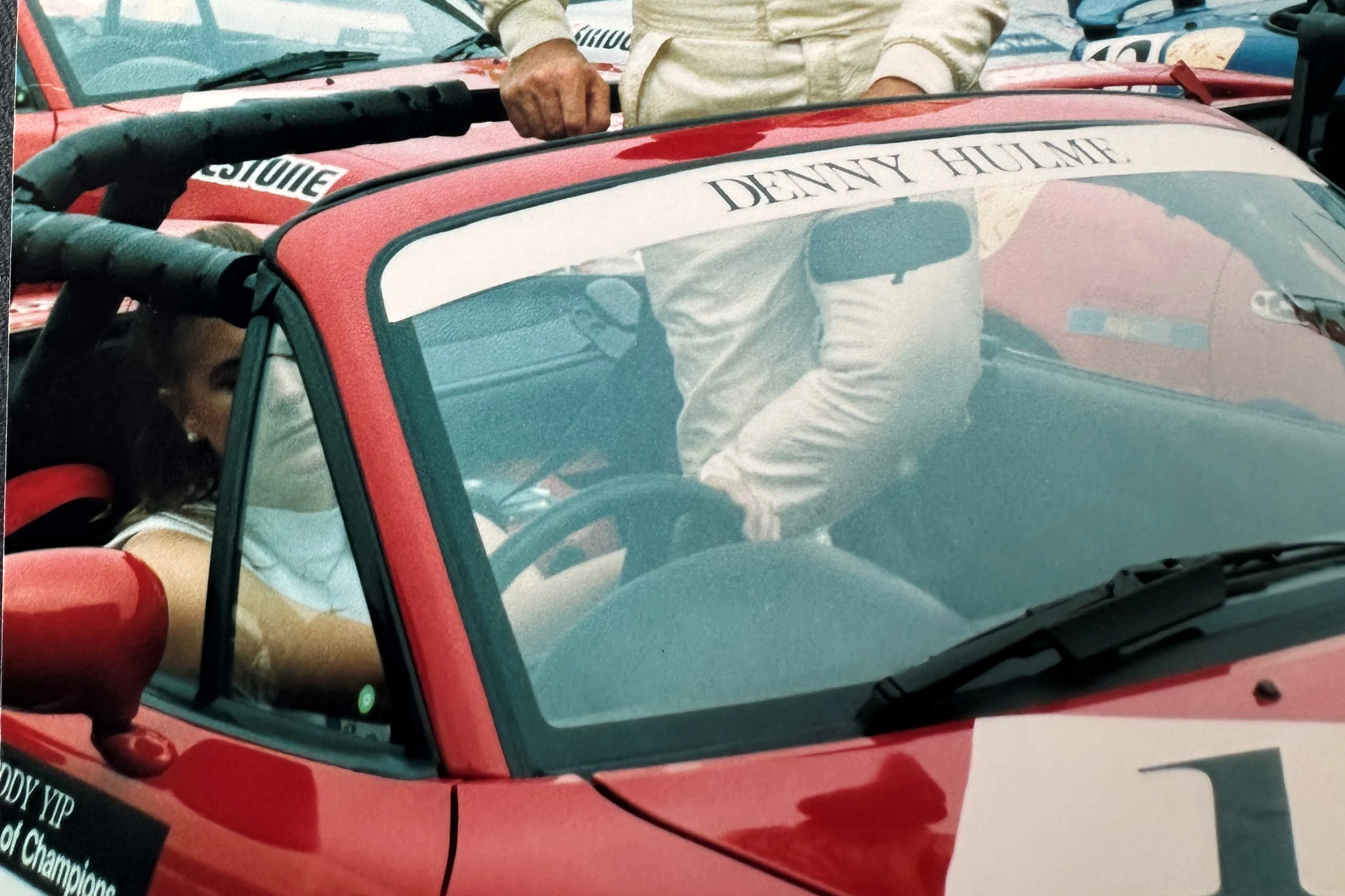 Archive photograph of a Adele Hulme sitting in Denny Hulme's race car.