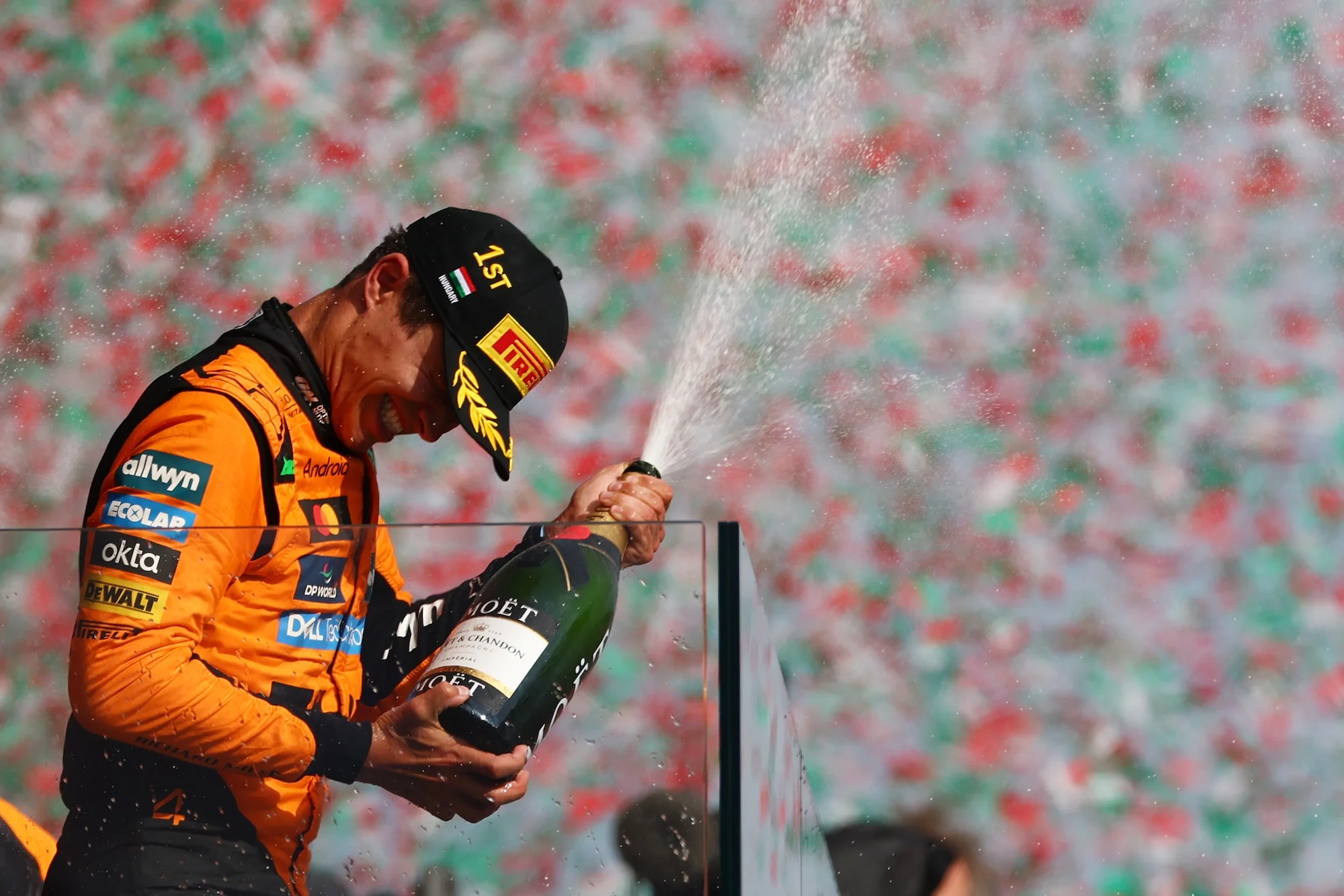 Lando Norris celebrates with Champagne on the podium during the Hungarian grand prix