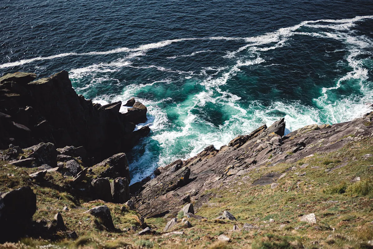 Klippe über dem Meer mit brechenden Wellen an einem sonnigen Tag.