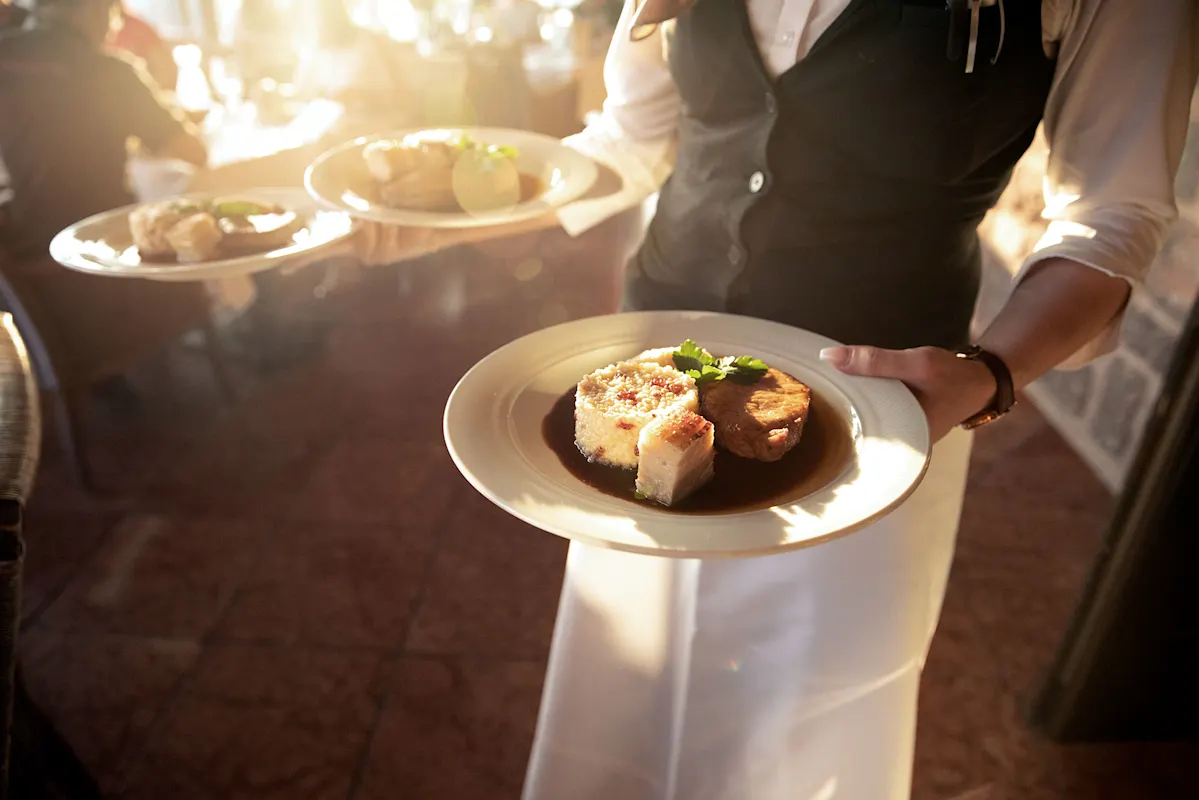 Three fine main courses being served, stylish dining atmosphere in the background.