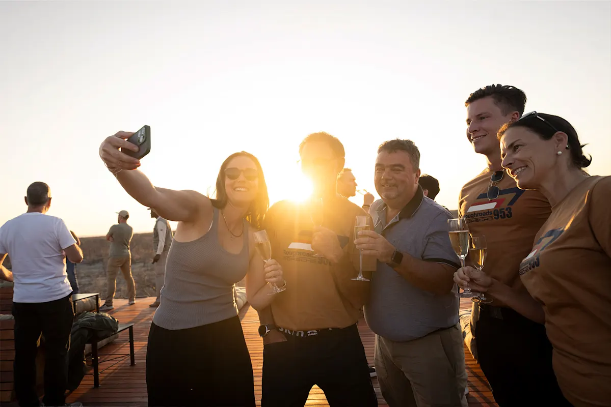 Fünf Freunde machen Sonnenuntergang-Selfie mit Getränken.