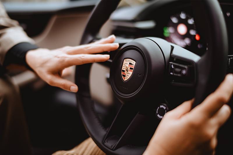Hand drückt Hupe am Porsche-Lenkrad
