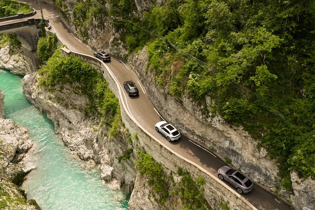 Vier Autos auf Bergstraße am Fluss und Klippen.