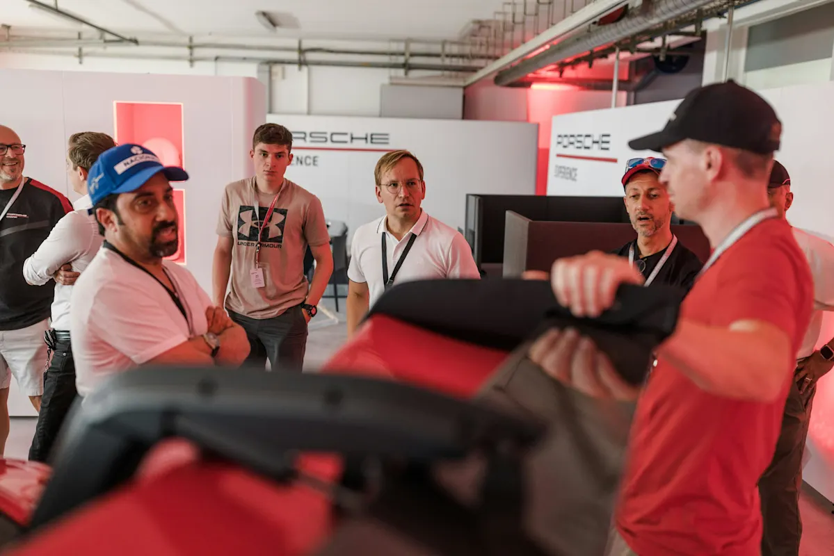 Männer diskutieren Funktionen im Porsche-Showroom.