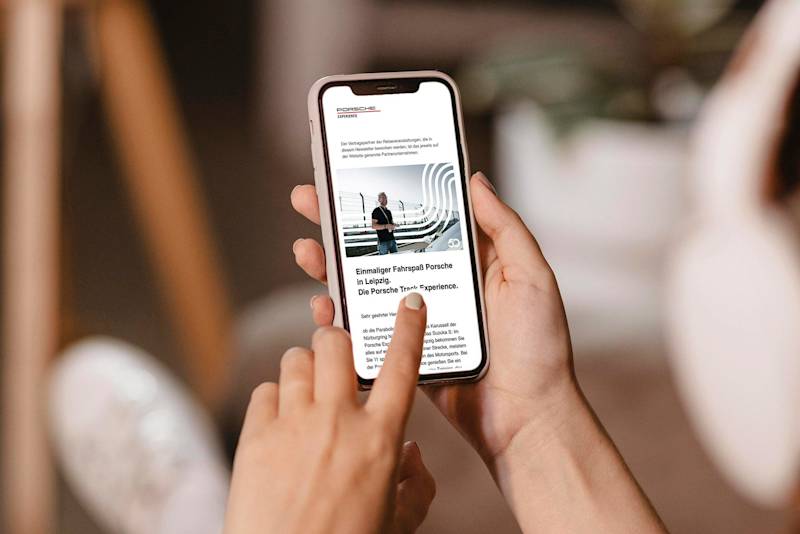 A person scrolls through a webpage on a smartphone indoors.
