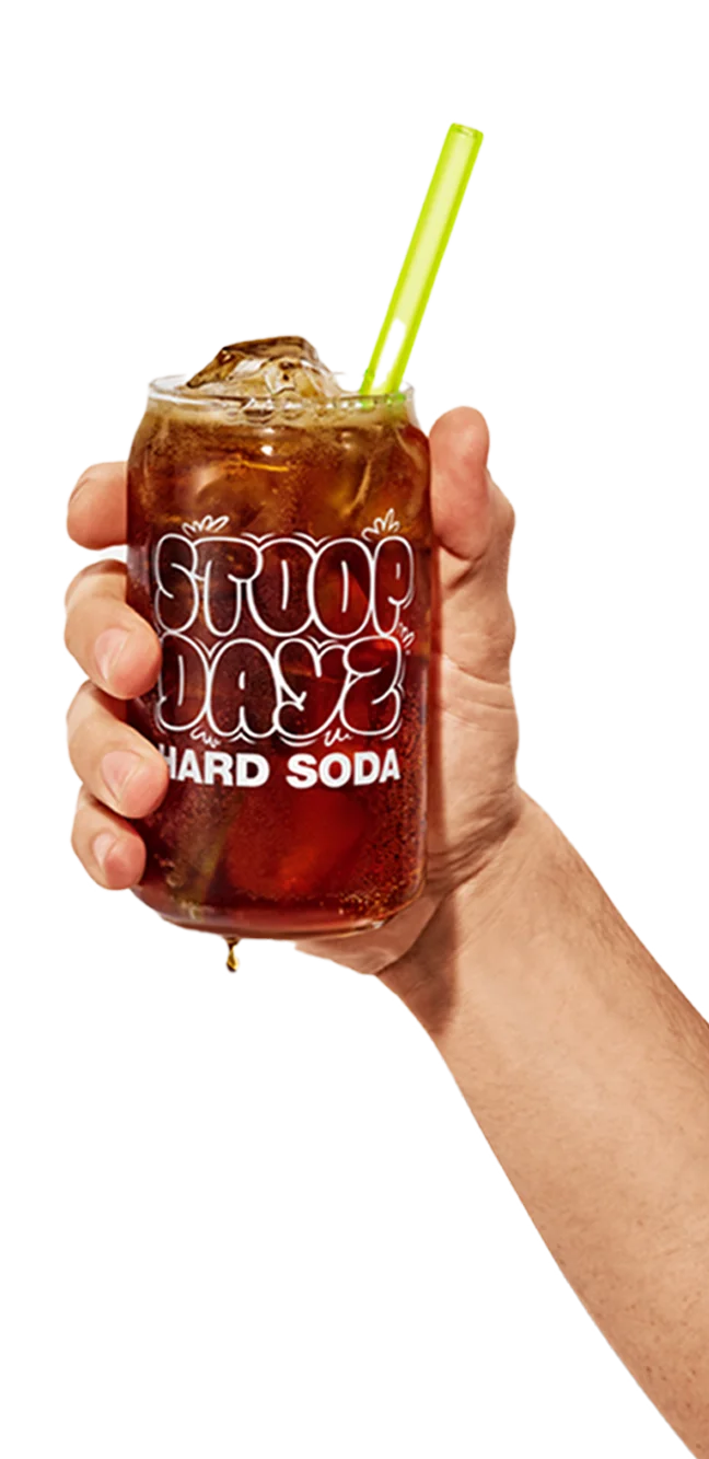 Person holding a glass of Root Beer Stoop Dayz Hard Soda with ice and a straw