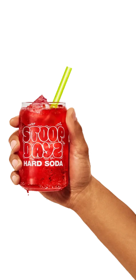 Person holding a glass of Cherry Stoop Dayz Hard Soda with ice and a straw.