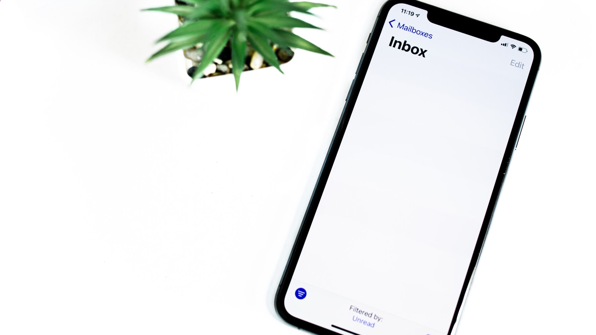 This image shows a smartphone next to a plant and is intended to illustrate the article "AWS SMTP: Integrating Amazon SES for Powerful SMTP Capabilities in the Cloud".