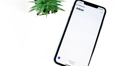 This image shows a smartphone next to a plant and is intended to illustrate the article "AWS SMTP: Integrating Amazon SES for Powerful SMTP Capabilities in the Cloud".