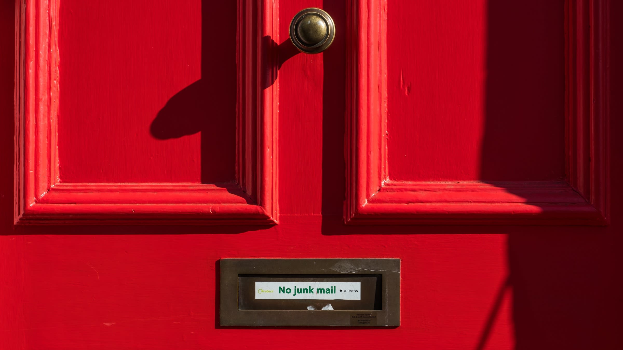 This picture shows a red front door with "No junk mail" written on the mail slot. It is intended to illustrate the article "Best Practices for Using Amazon SES: Authentication, Compliance, and List Hygiene". 