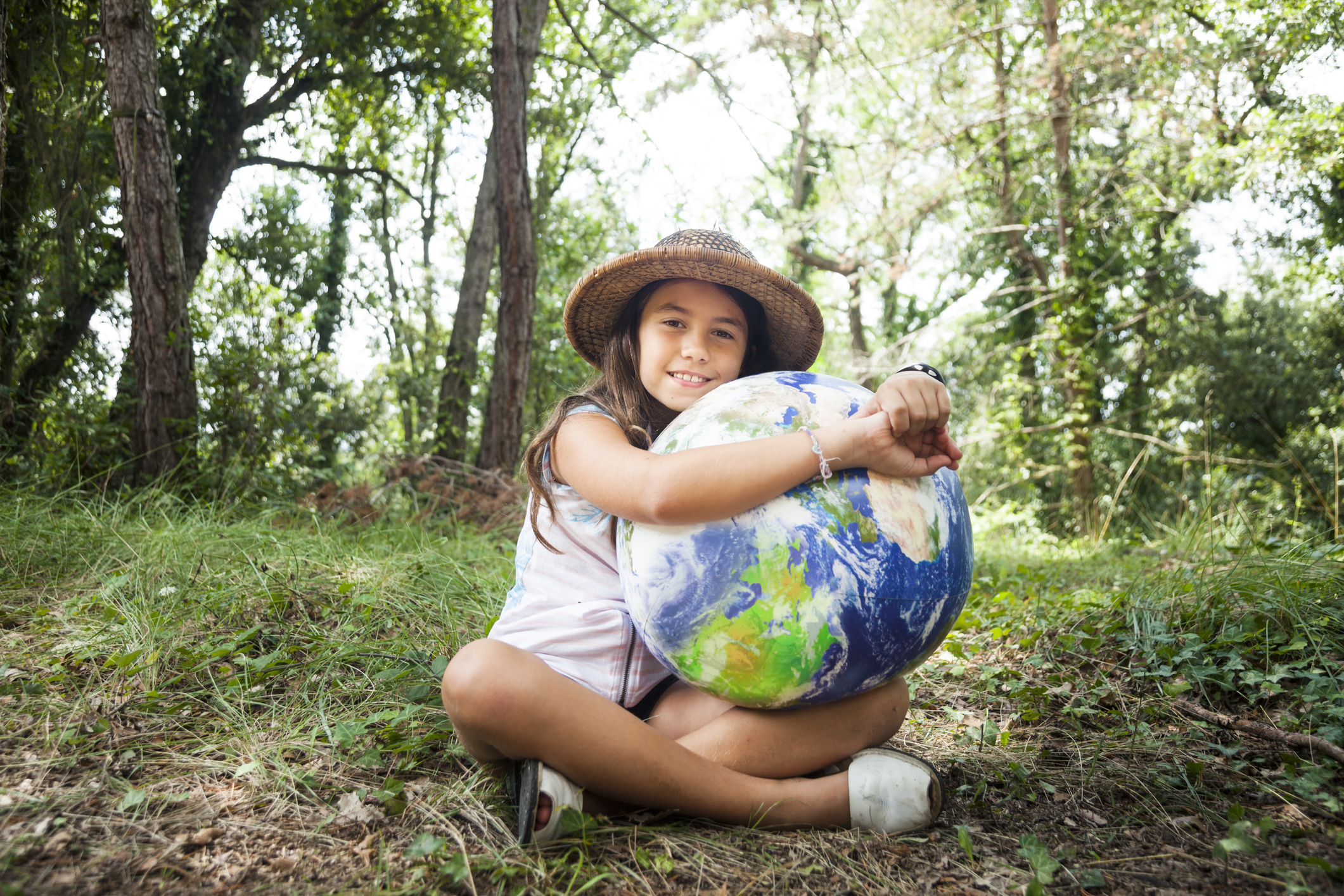 young girl hugging a globe