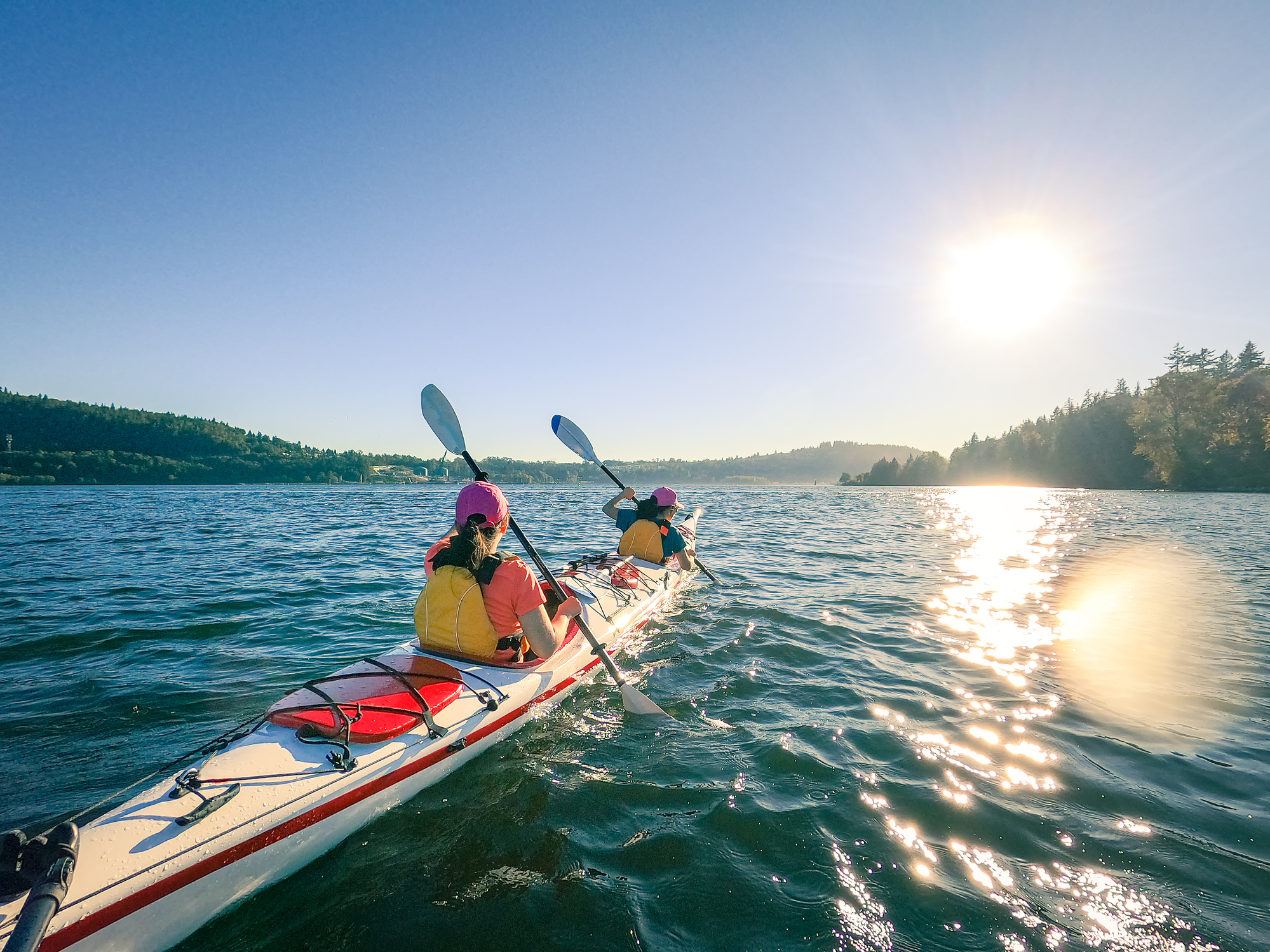 Kayaking in nature with the sun shining for eco-friendly travel tips