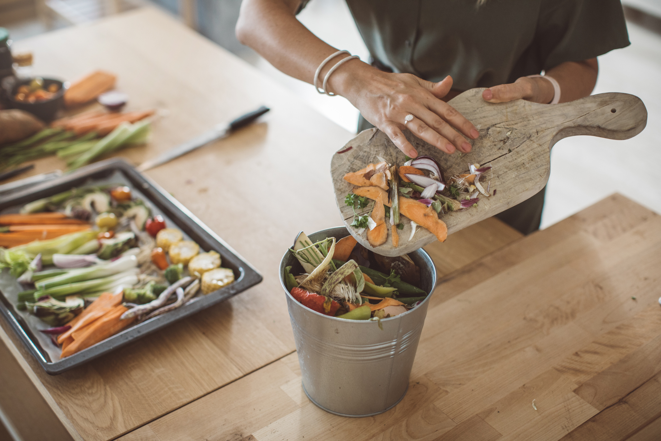 Woman composting food scraps in an apartment kitchen