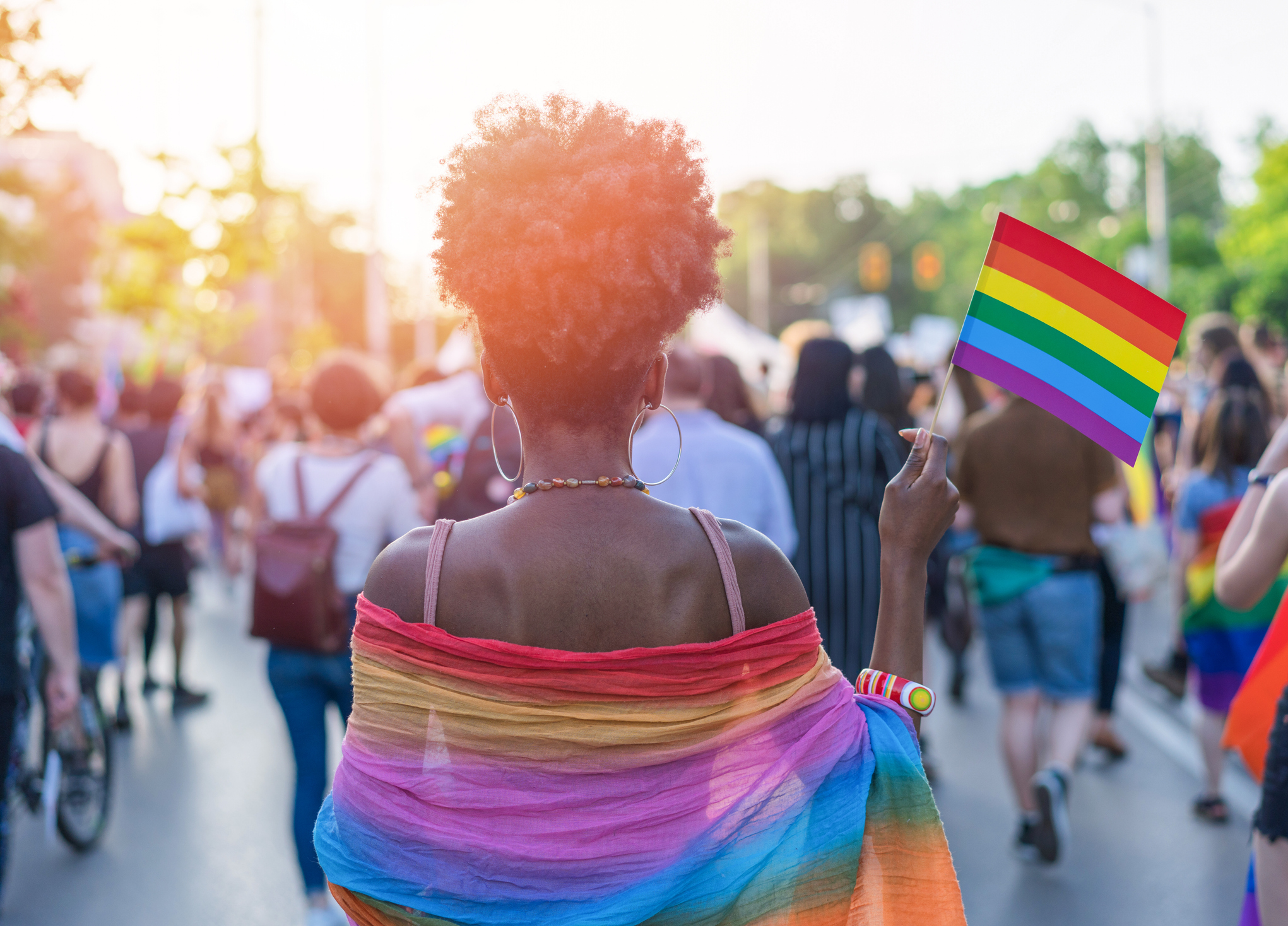 A woman holding a rainbow flag for Pride Month.
