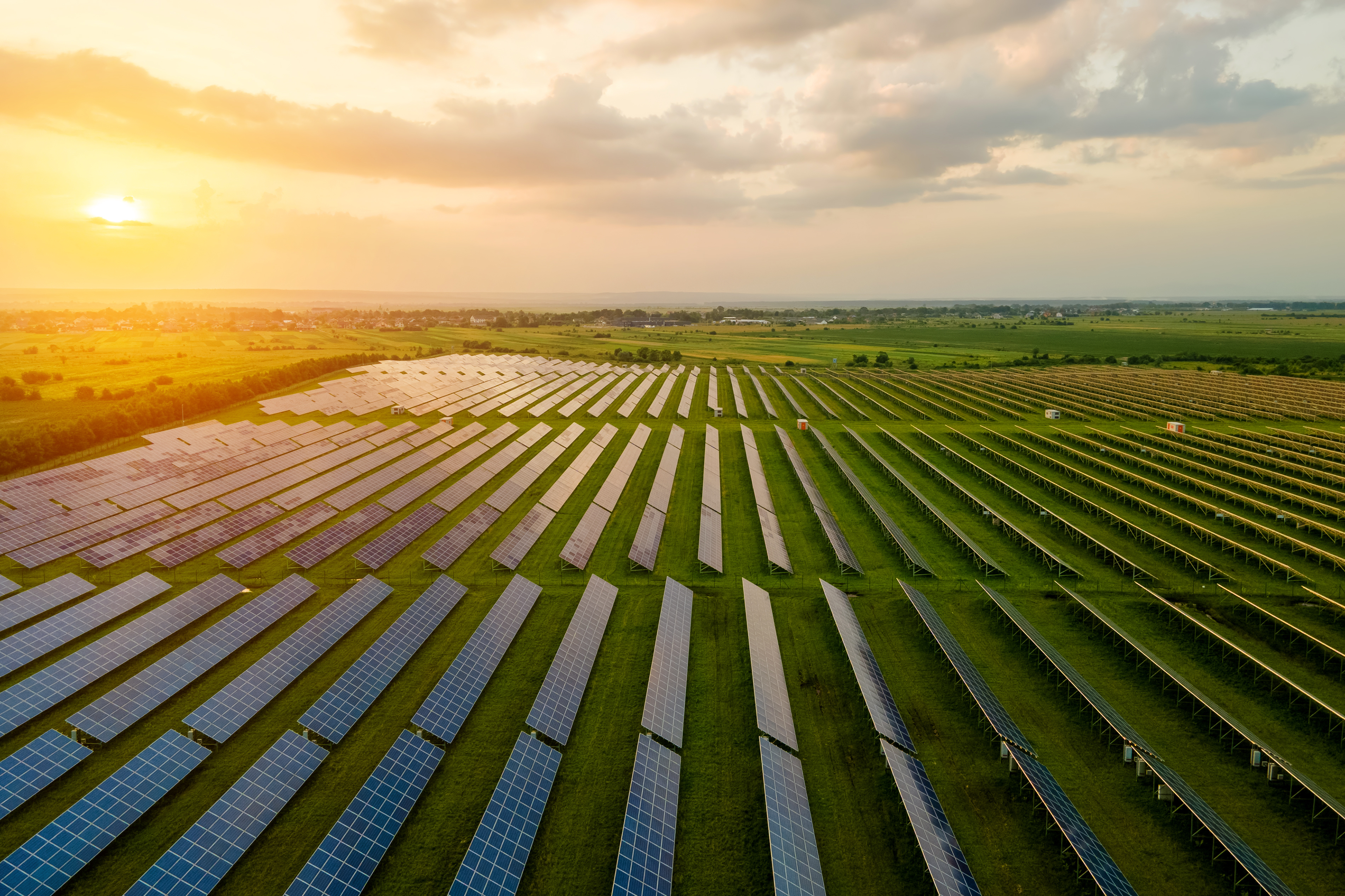 Sun rising over a community solar farm with solar panels