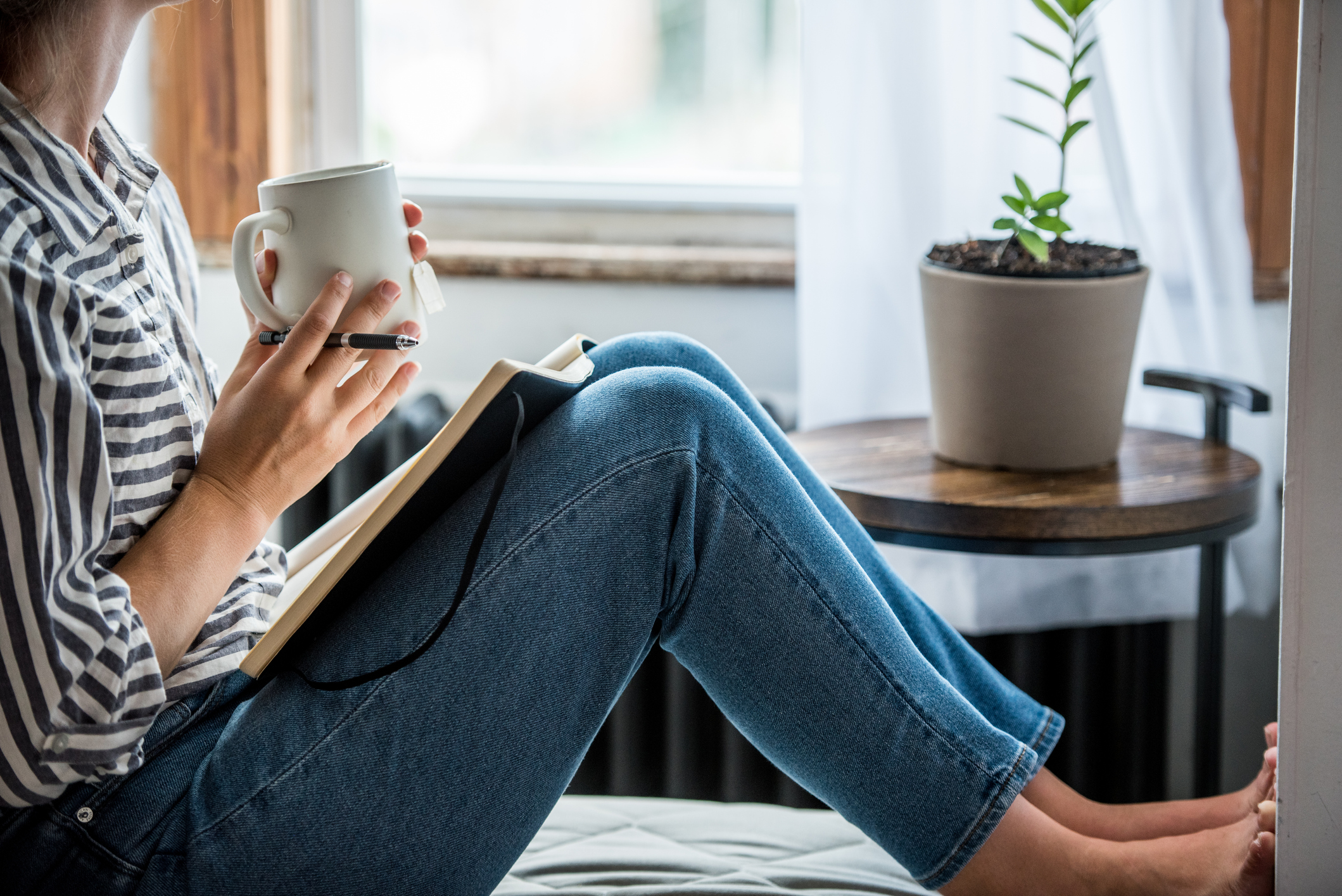 Woman journaling and drinking coffee