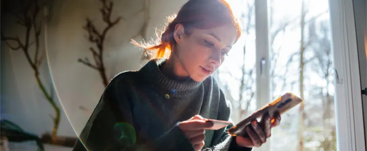 A woman reviewing her credit card and finances after debt consolidation.