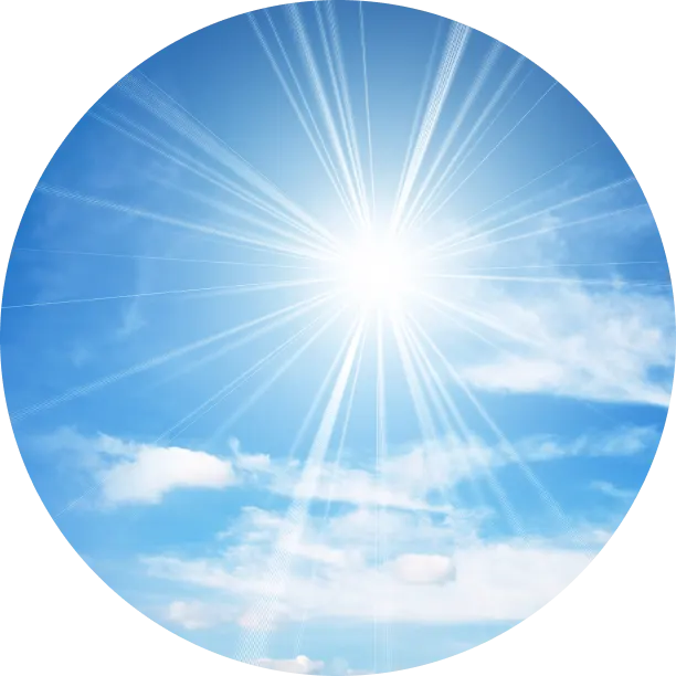 A bright sun shining in a clear blue sky with scattered clouds.