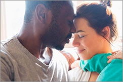 Couple embracing whilst holding small child