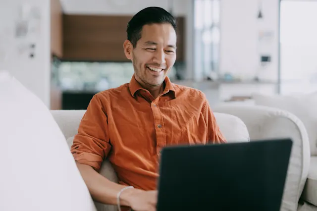 Man smiling while using laptop
