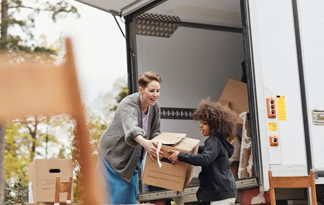 Woman and child taking boxes out of moving truck
