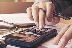 person holding pen and interacting with calculator