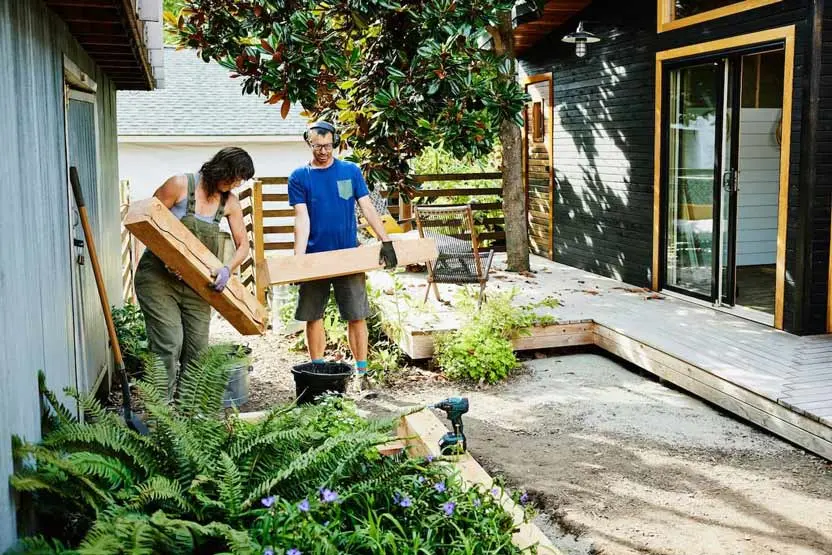 a man and a women working on a backyard landscaping project