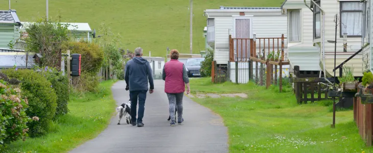 A couple walking their dog at a mobile home