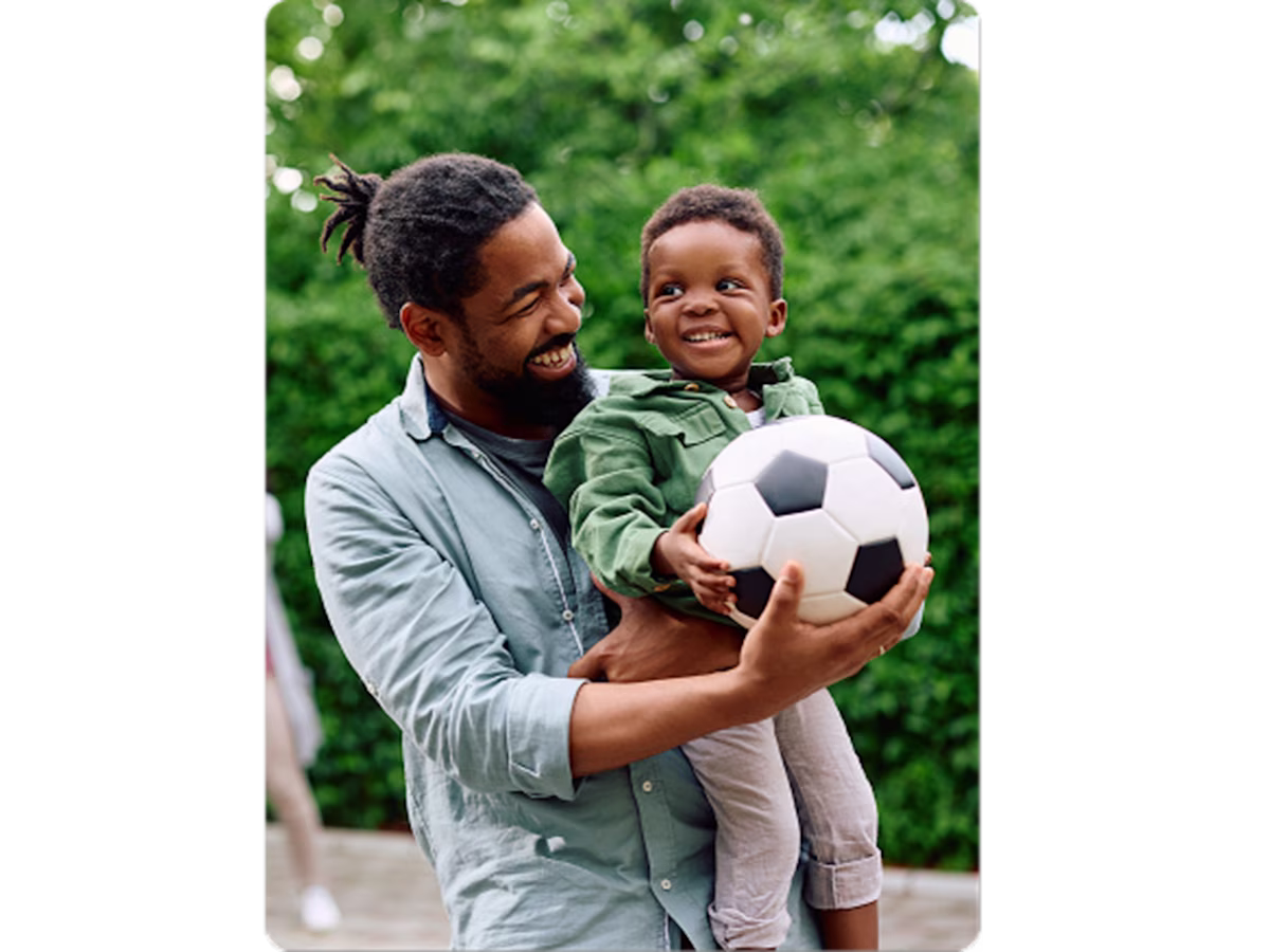 Man and child with soccer ball
