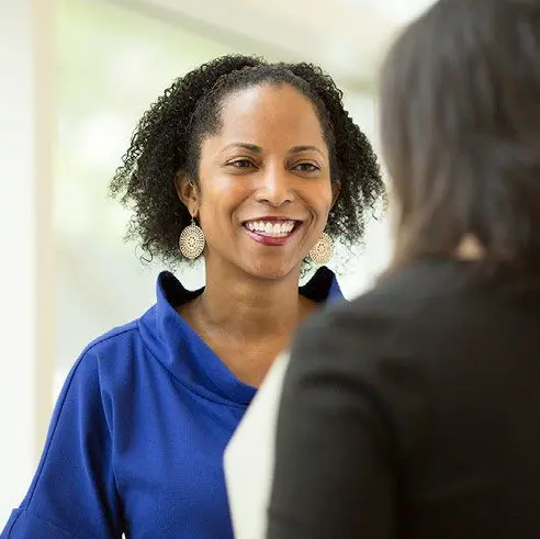 Mujer sonriendo mientras mantiene una conversación