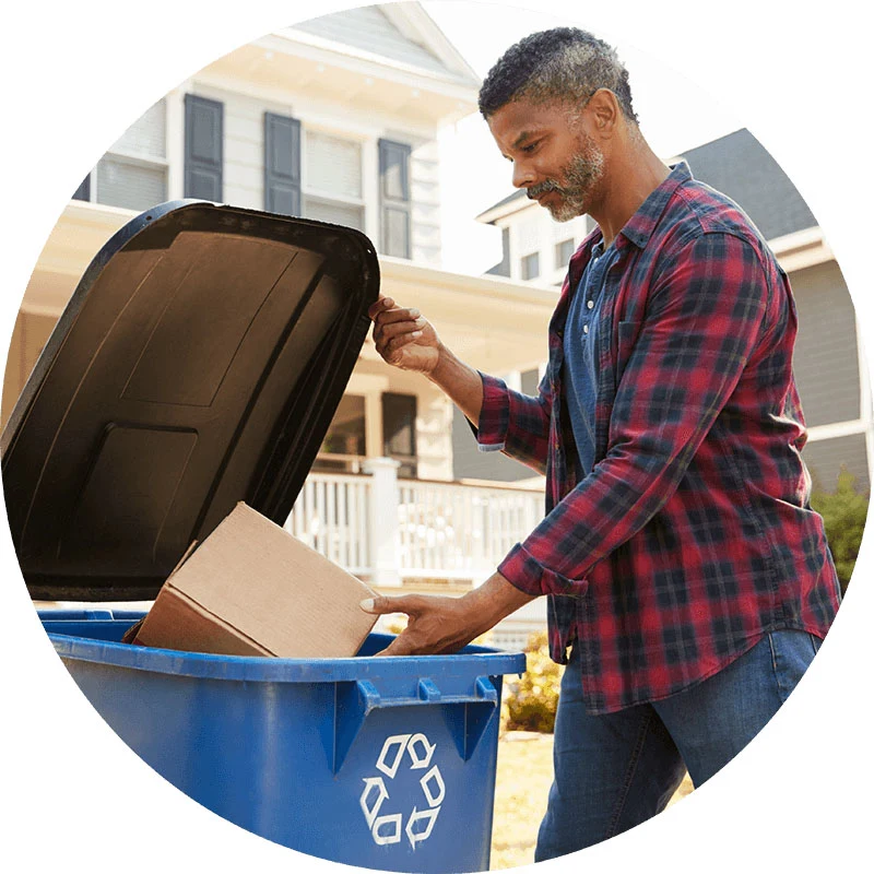 Hombre tirando un empaque en un contenedor para reciclaje