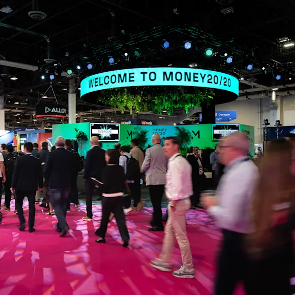 Delegates entering Money20/20 show with a sign that says Welcome to Money20/20