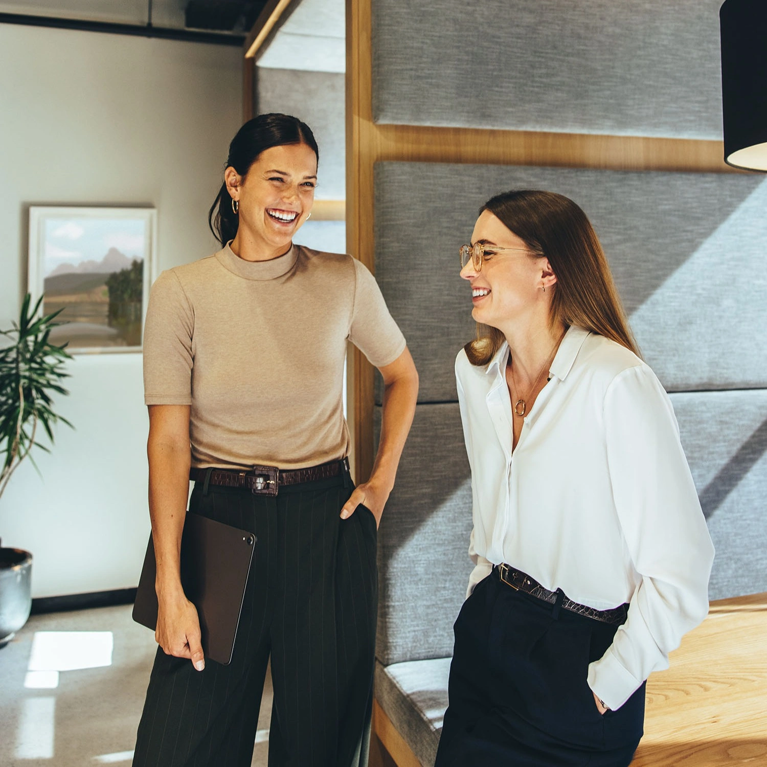 Geschäftsfrauen lachen gemeinsam im Büro - 1:1