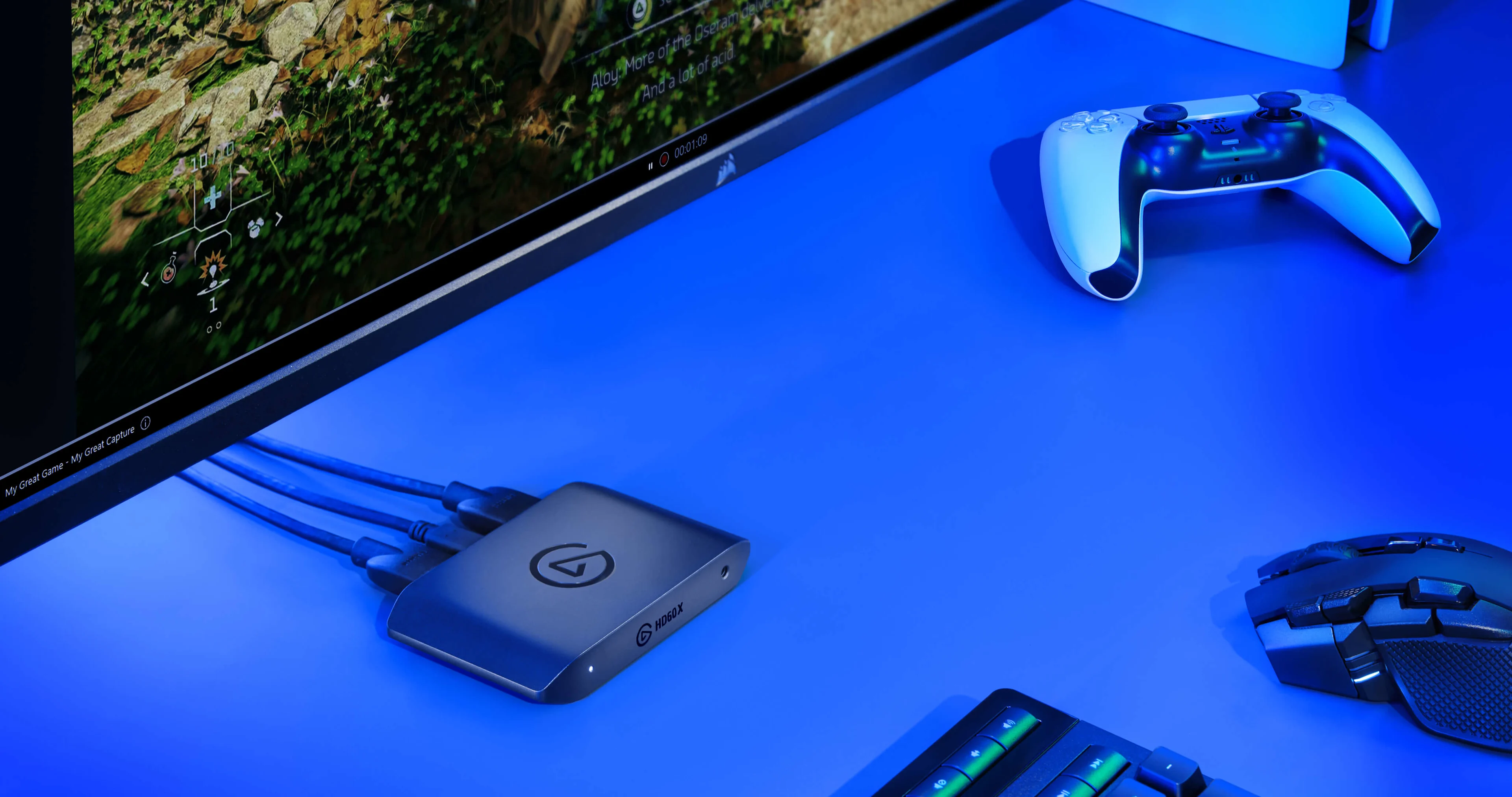 HD60 X on a blue table next to a white controller, keyboard and mouse