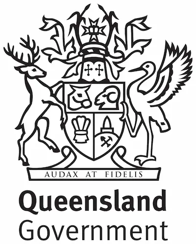 The logo for the Queensland Government features a detailed black and white coat of arms. The shield displays a sheaf of wheat, bull and ram heads, and two stalks of sugar cane, with a column of gold rising from quartz. Above the shield is the state badge, surrounded by sugar cane stalks. The coat of arms is flanked by a brolga on the right and a red deer on the left. Below the shield is a banner with the motto "AUDAX AT FIDELIS." "Queensland Government" is written in bold black letters beneath the coat of arms.