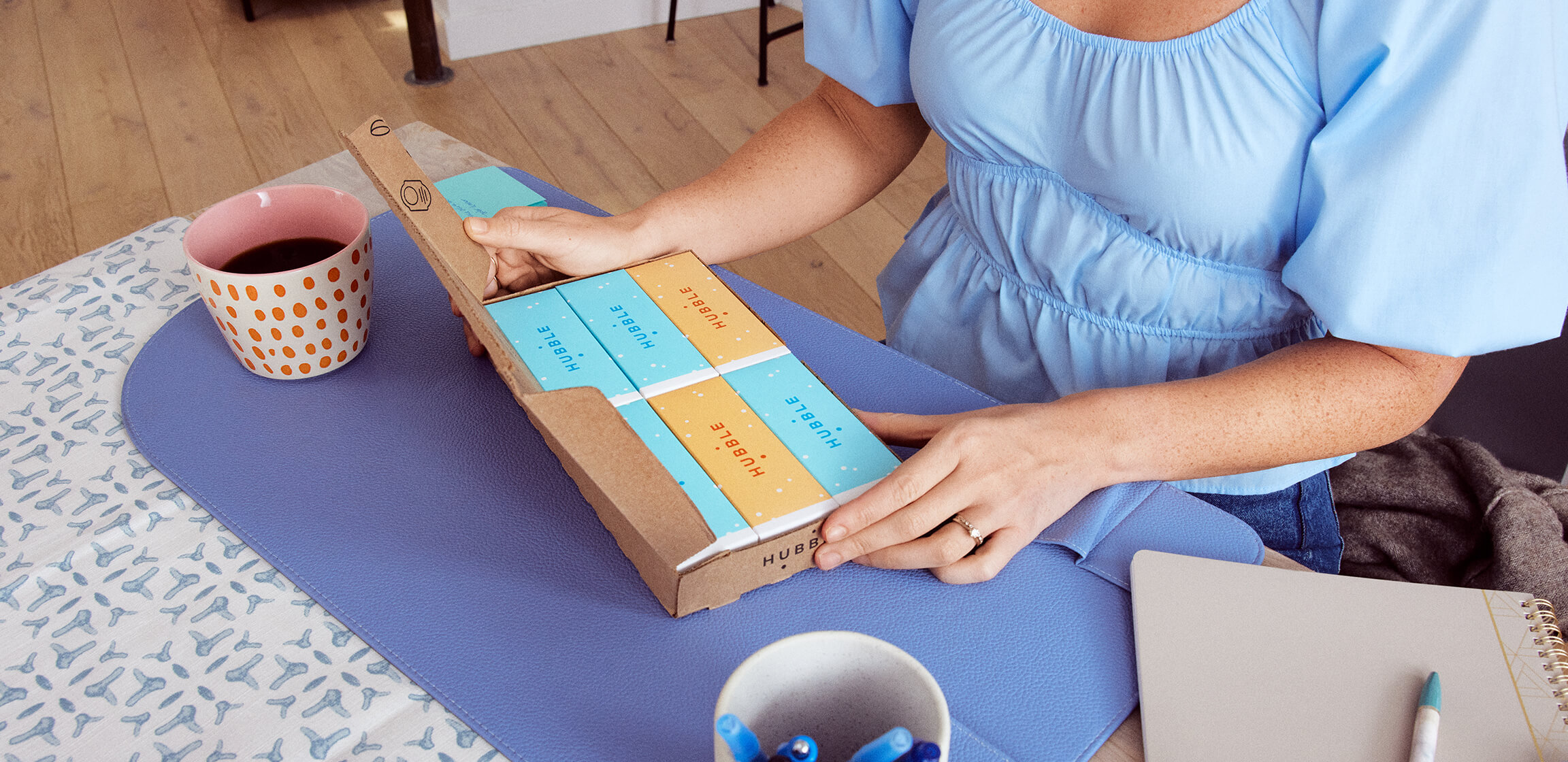 Woman unboxing a new delivery of Hubble Contacts