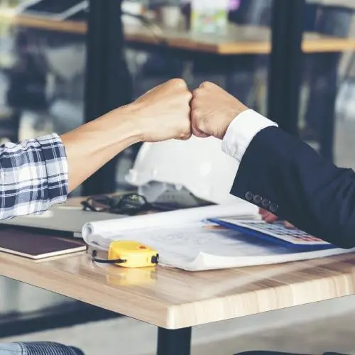 Two people fist-bumping at work