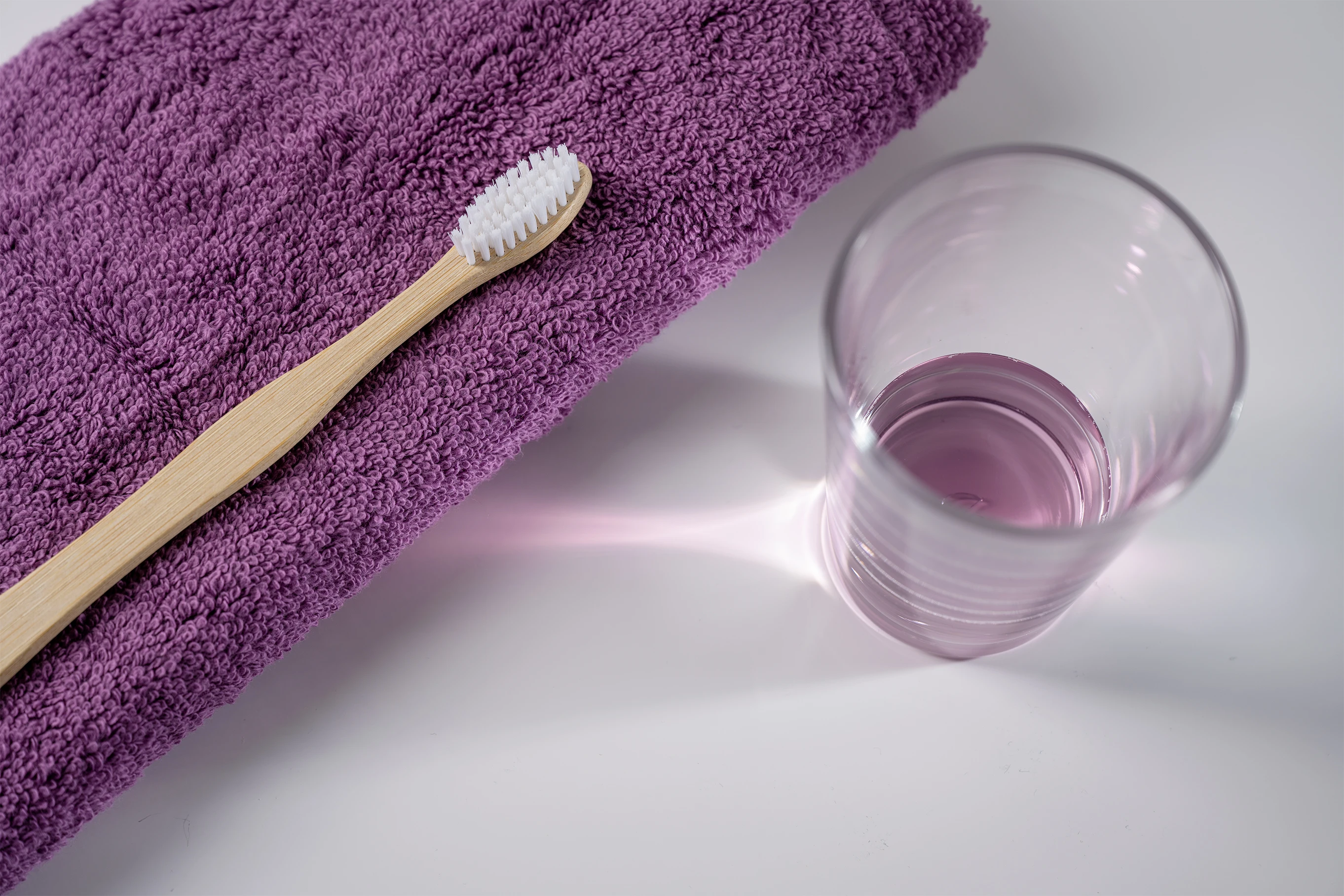 Zahnpasta auf einem lila Handtuch und daneben eine Munspülung