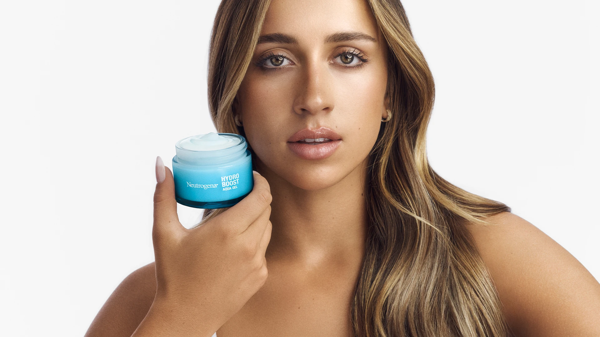 Tate McRae hält Neutrogena Hydro Boost Aqua Gel in der Hand und schaut in die Kamera